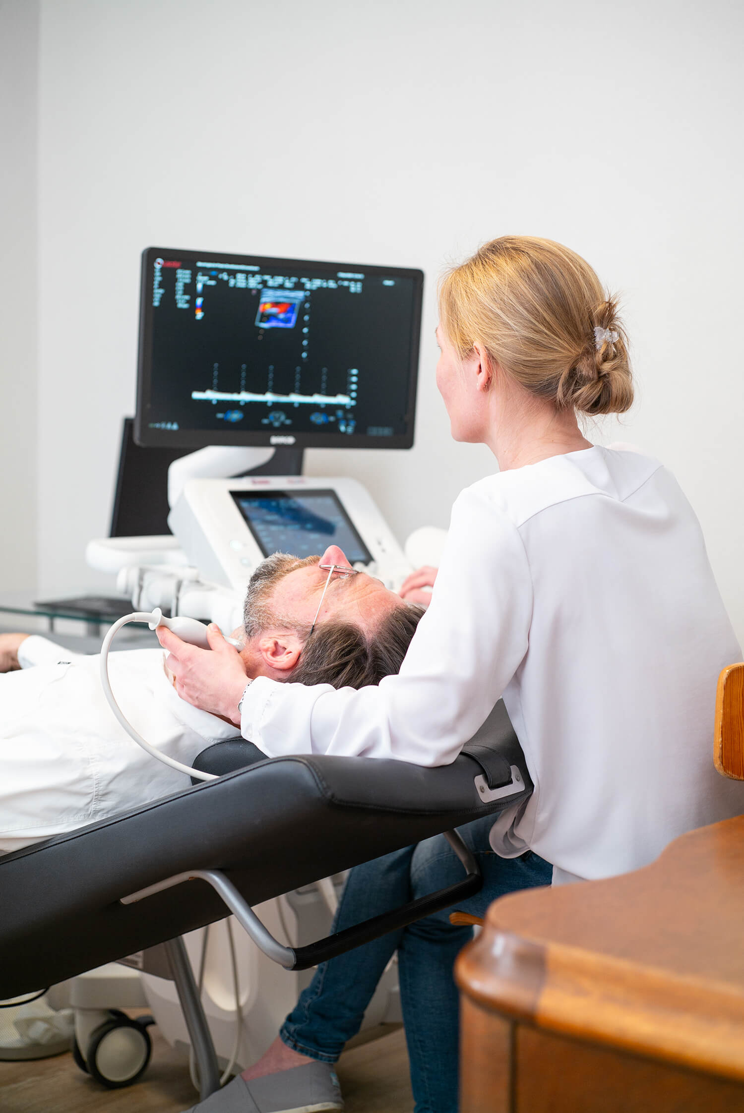 Dr. med. Lisa Schönbrunn untersucht einen Patienten mit dem Ultraschallgerät